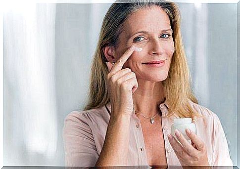 woman applying cream to firm her skin