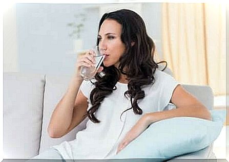 A woman drinking a glass of water. 