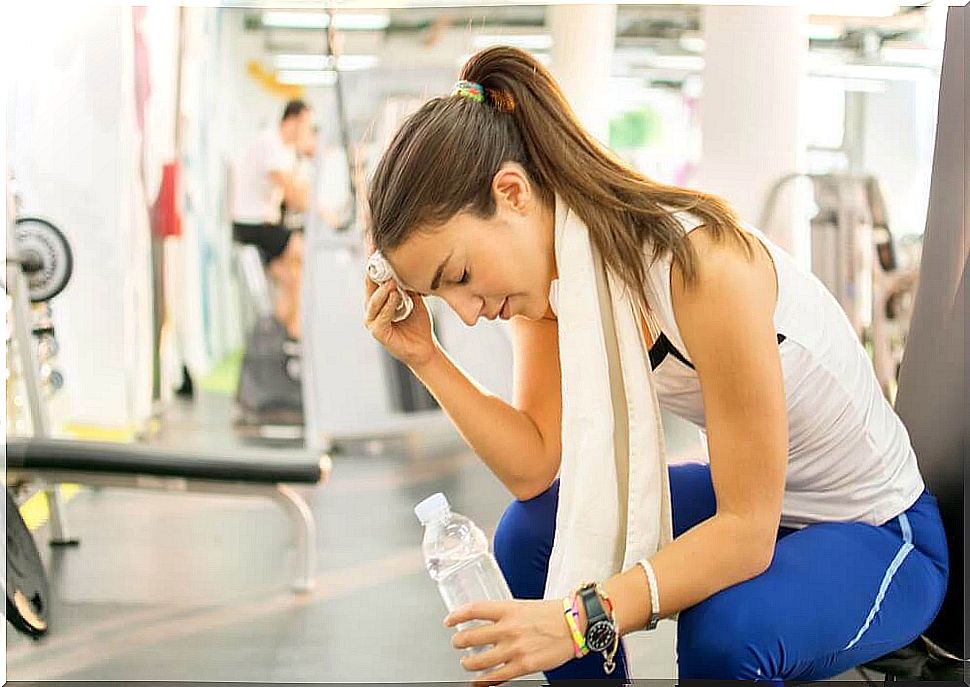 A woman in a gym who has a side stitch